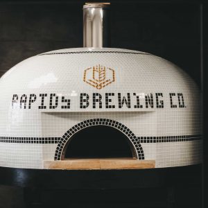 Tiled wood-fired oven with Rapids Brewing Company logo